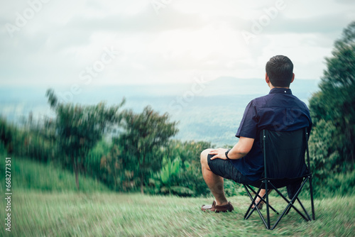 Traveling man relaxing after hiking Sit on a chair and admire the mountain views and natural beauty
