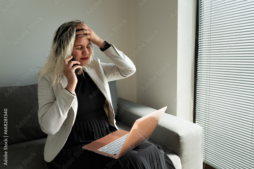 Elegant woman working online with her laptop and smartphone from home. Elegant woman working online with her laptop and smartphone from home.