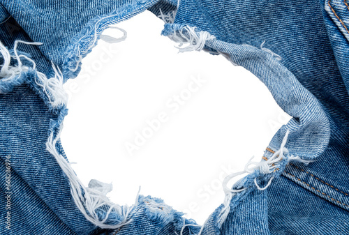 Hole in denim on a white background. Ripped jeans