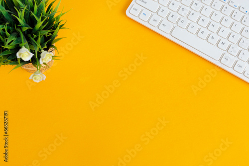 Directly above view of office desk with yellow background. Copy space. Flat lay.