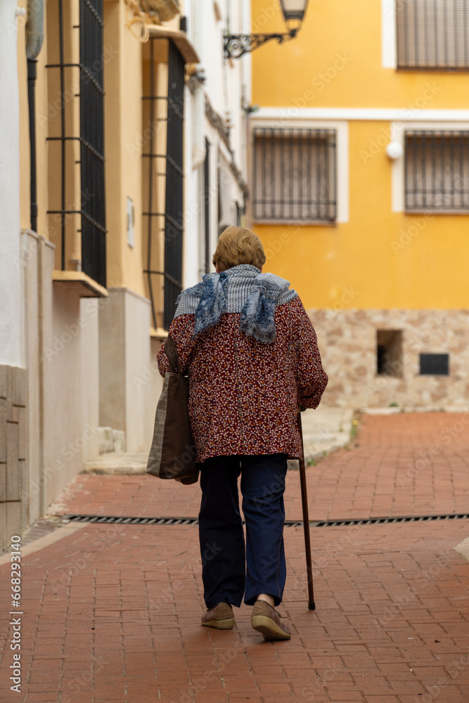 Senior woman walking relaxed on the old town street.