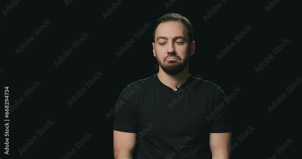 Sad man on black studio background. Feeling hopelessness, loneliness, bad fortune, loss, unlucky news