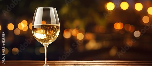 White wine on wooden table in dimly lit romantic restaurant ambiance photo