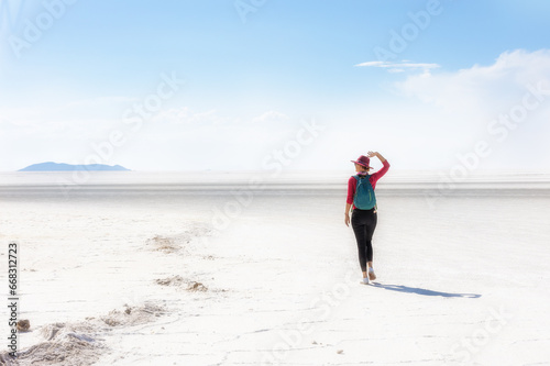 A girl in a hat walks on a salt lake. Salar de Uyuni, Bolivia