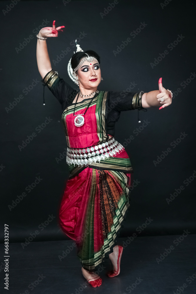 Woman performing Odissi dance in colorful costume. Indian classical dance forms.
