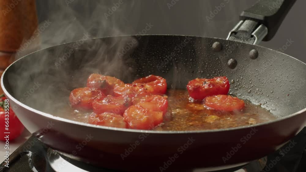 Fresh cherry tomatoes in a frying pan with olive oil and spices. Cooking tomato sauce. Traditional Italian Mexican Asian dish. High quality studio shot for cafe, restaurant close up. Fresh cherry tomatoes in a frying pan with olive oil and spices. Cooking tomato sauce. Traditional Italian Mexican Asian dish. High quality studio shot for cafe, restaurant close up.