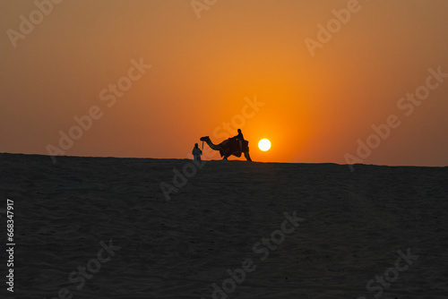 Camel Caravan at Sunset Time in the Doha Desert Photo, Doha Qatar © raul77