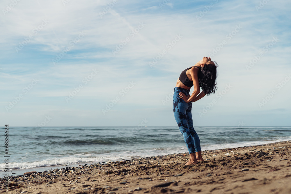 A beautiful brunette girl is dancing on the beach by the sea on the sand A beautiful brunette girl is dancing on the beach by the sea on the sand