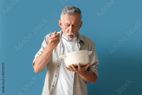Mature man with spoon and c...