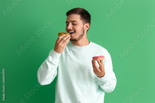 Young man with tasty donuts...