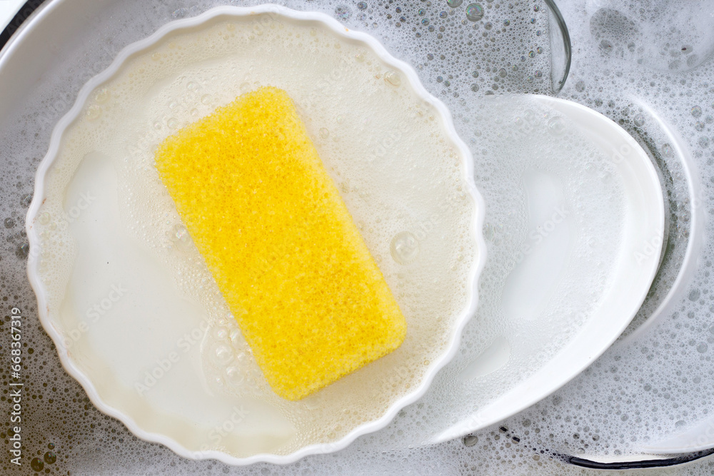 Dishes and bowls in water and bubbles of dishwashing liquid. Kitchen work Dishes and bowls in water and bubbles of dishwashing liquid. Kitchen work