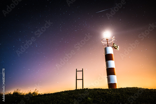 A lighthouse beaming under stars