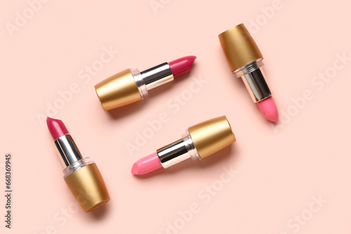 Different bright lipsticks on pink background