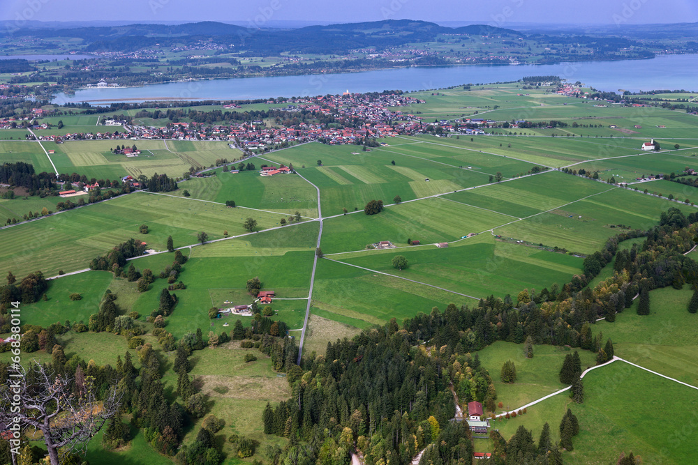 Aerial drone view valley, fields, village, lake at foot of Alpine mountains in Bavaria, Germany. Aerial drone view valley, fields, village, lake at foot of Alpine mountains in Bavaria, Germany.