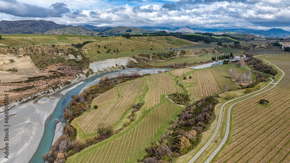 The blue water of the Awatere river flowing through agricultural farmland in a rural valley