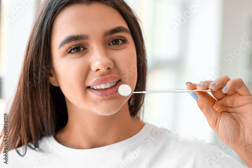 Smiling young woman with dental tool at home, closeup