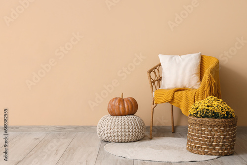 Fototapeta Naklejka Na Ścianę i Meble -  Interior of living room with armchair, pumpkin and chrysanthemum flowers