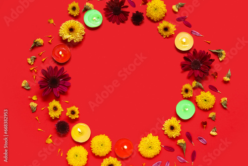 Fototapeta Naklejka Na Ścianę i Meble -  Frame made of burning candles and beautiful flowers on red background. Divaly celebration