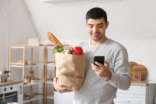 Young man with grocery bag ...