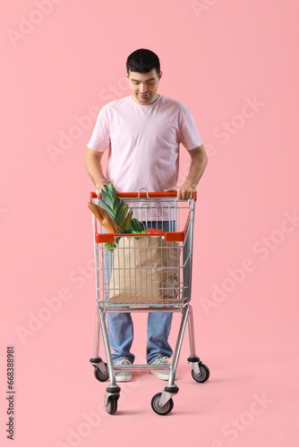 Young man pushing shopping ...
