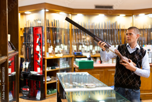 Canvas Print Seller demonstrates a combat winchester in the gun store