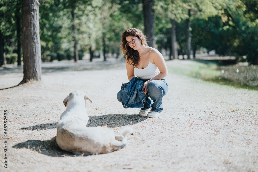 An attractive girl playing with her dog while hanging out in the park on a beautiful sunny autumn day. An attractive girl playing with her dog while hanging out in the park on a beautiful sunny autumn day.