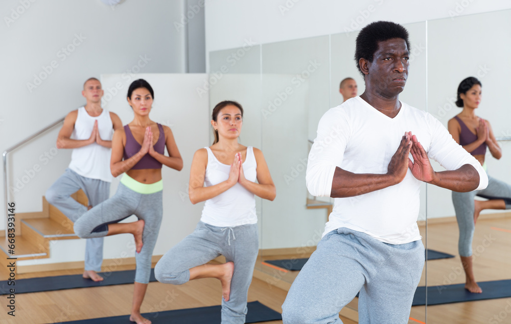 People studying new position at yoga modern school