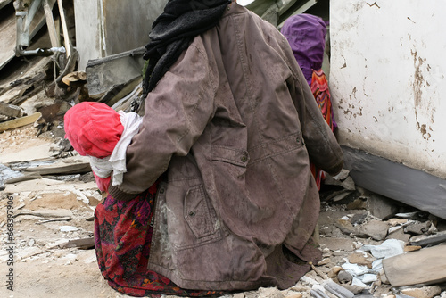 Mother with children near a destroyed house