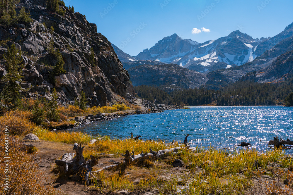 Hiking in Little Lakes Valley in the Eastern Sierra Nevada Mountains outside of Bishop, California. Alpine lakes, fall leaf colors, snow capped mountains and evergreen trees combine to make a pictures
