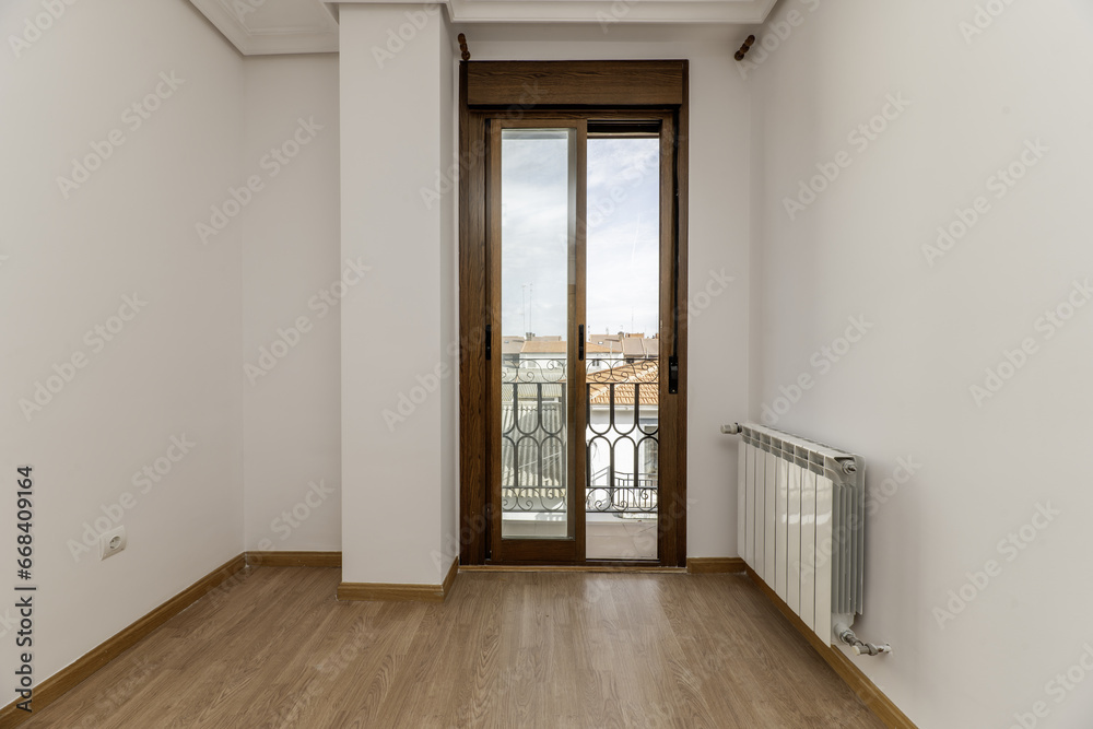 empty room with white painted walls and light wooden floors and access to a balcony with sliding aluminum and glass doors empty room with white painted walls and light wooden floors and access to a balcony with sliding aluminum and glass doors