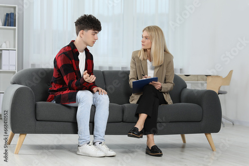 Psychologist working with teenage boy in office. Teenager problems