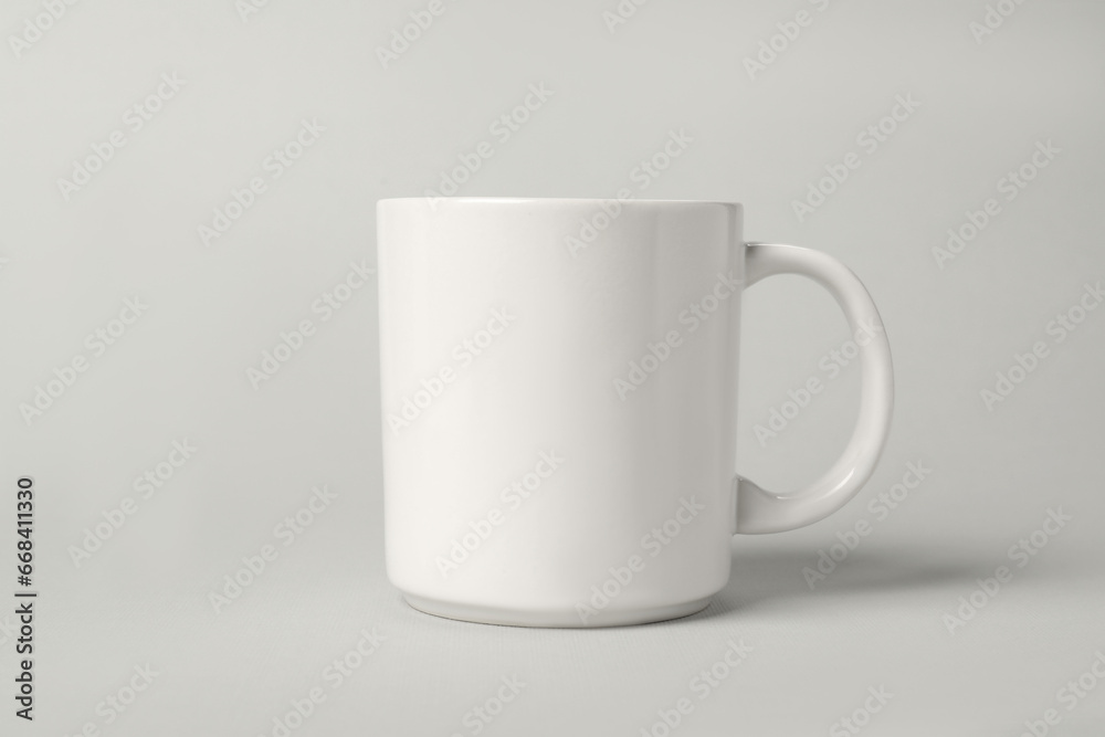 One white ceramic mug on light grey background One white ceramic mug on light grey background
