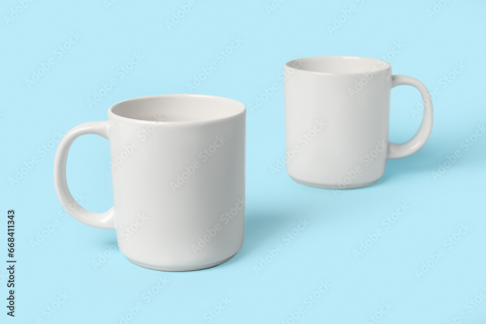 Obraz premium Two white ceramic mugs on light blue background