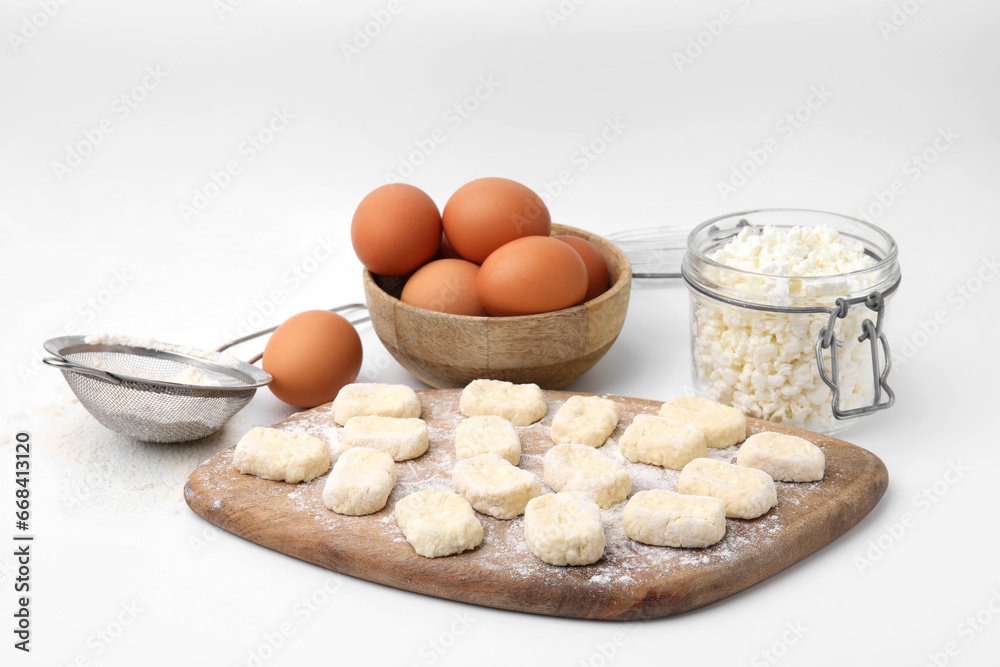 Making lazy dumplings. Wooden board with cut dough and ingredients isolated on white Making lazy dumplings. Wooden board with cut dough and ingredients isolated on white