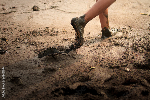 Someone is walking barefoot in the mud while searching for 'kijing' shells photo