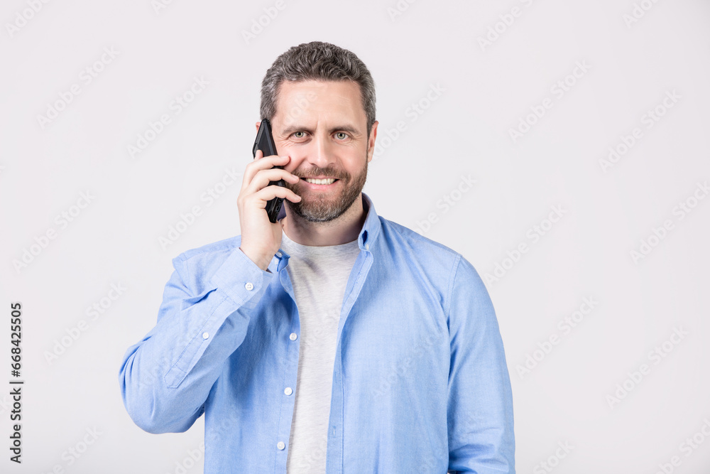 smiling man has communication call on phone isolated on studio background. smiling man has communication call on phone isolated on studio background.