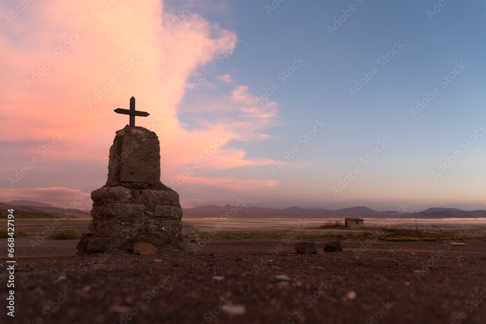 monument with a cross in the middle of the desert with beautiful sunset colors