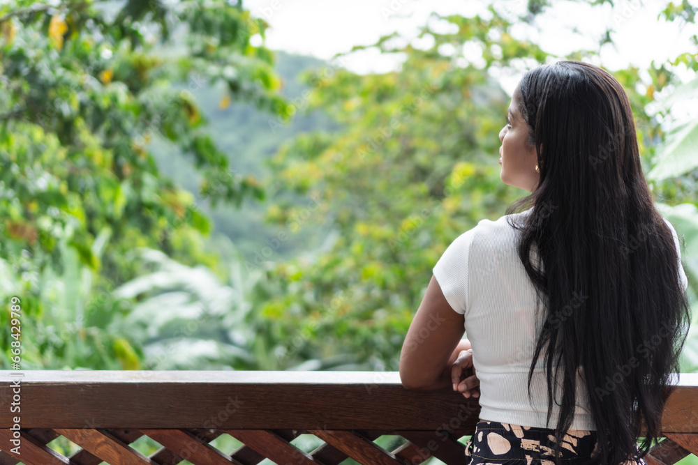 Naklejka premium Latin woman standing on balcony