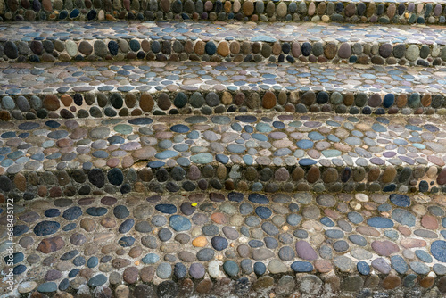 Steps made of flat rounded multi-colored stones. The stones were brought from the sea coast, laid side by side and filled with cement mortar.