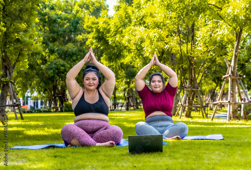 Fat woman overweight training doing yoga at the park happy smiling women in yoga class exercising outdoors. the park in the morning
