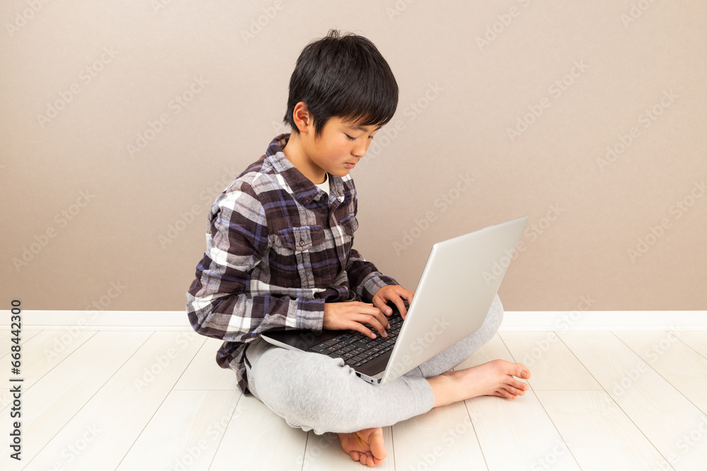 床に座ってパソコンをする子供 床に座ってパソコンをする子供
