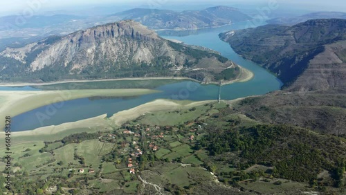 An aerial view of a mountain range with a river running between it, surrounded by a village in Bulgaria photo