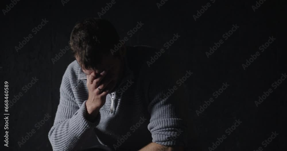 Portrait shot of male suffering from depression sitting alone at home in the dark, Mental health Concept Portrait shot of male suffering from depression sitting alone at home in the dark, Mental health Concept