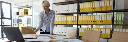 Businesswoman looks at papers in empty company office © megaflopp