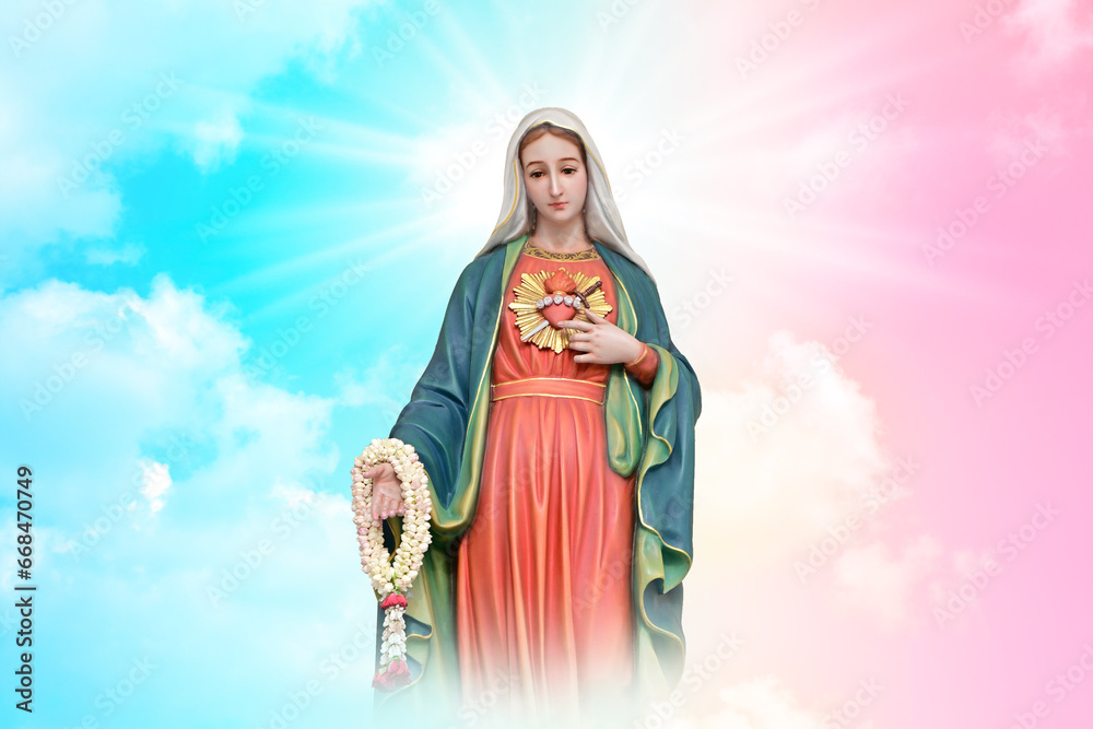 Fototapeta premium Statue of Our lady of grace virgin Mary with beautiful Sky Pastel with abstract colored background and wallpaper in sweet color. at Thailand.