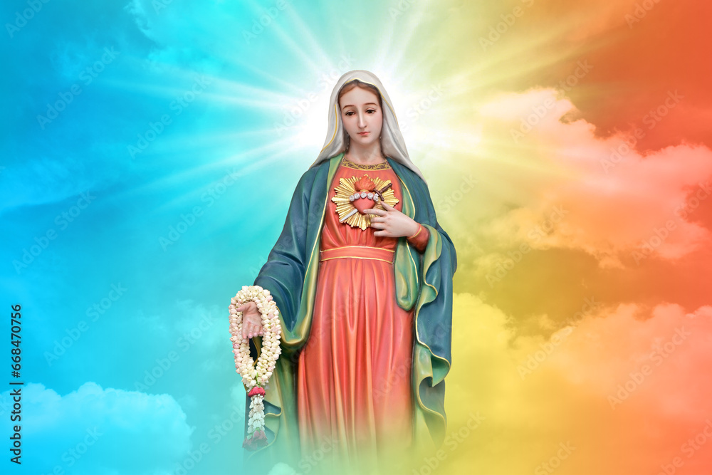 Fototapeta premium Statue of Our lady of grace virgin Mary with beautiful Sky Pastel with abstract colored background and wallpaper in sweet color. at Thailand.