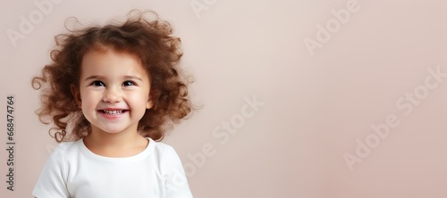 baby smiling and looking up to camera on a beigebackground photo