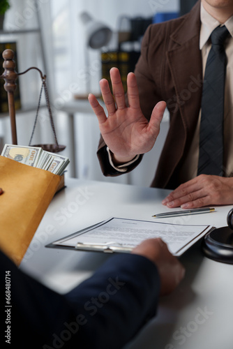 Фотография Businessman or accountant is rejecting and resisting partner bribery deals in joint financial settlement, illegal anti-bribery ideas