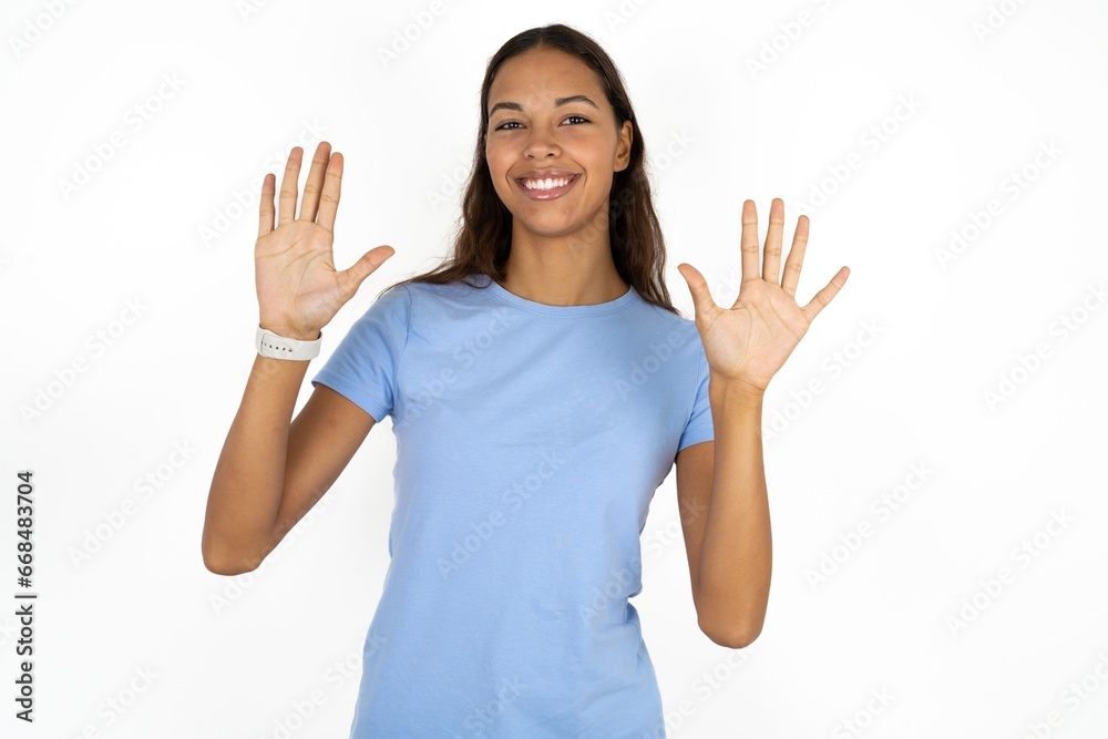 Beautiful girl wearing blue T-shirt showing and pointing up with fingers number ten while smiling confident and happy. Beautiful girl wearing blue T-shirt showing and pointing up with fingers number ten while smiling confident and happy.