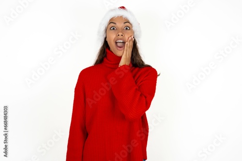 Shocked Beautiful girl wearing red sweater looks with great surprisment being very stunned, astonished with unexpected news, Facial expressions concept. photo